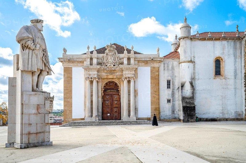 A student in traditional cloth walking through University of Coimbra