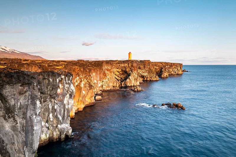 Orange lighthouse of Oendverdarnes stands on cliffs