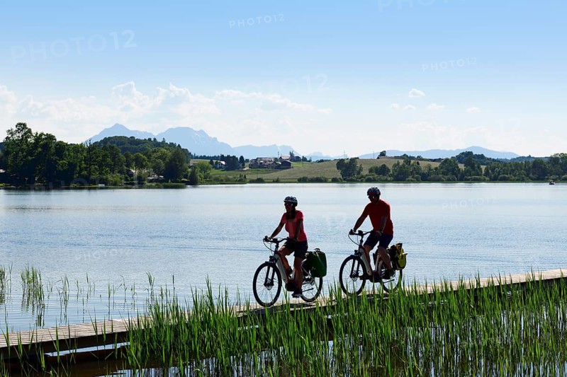 Couple with electric bikes riding on the shore