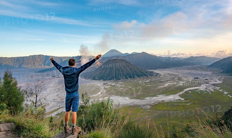 Young man stretches arms in the air