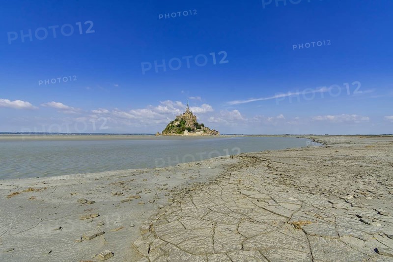 View over dried mud at the edge of the salt marshes at low tide on Mont-Saint-Michel