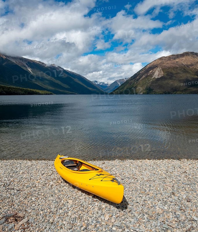 Yellow kayak on pebble beach