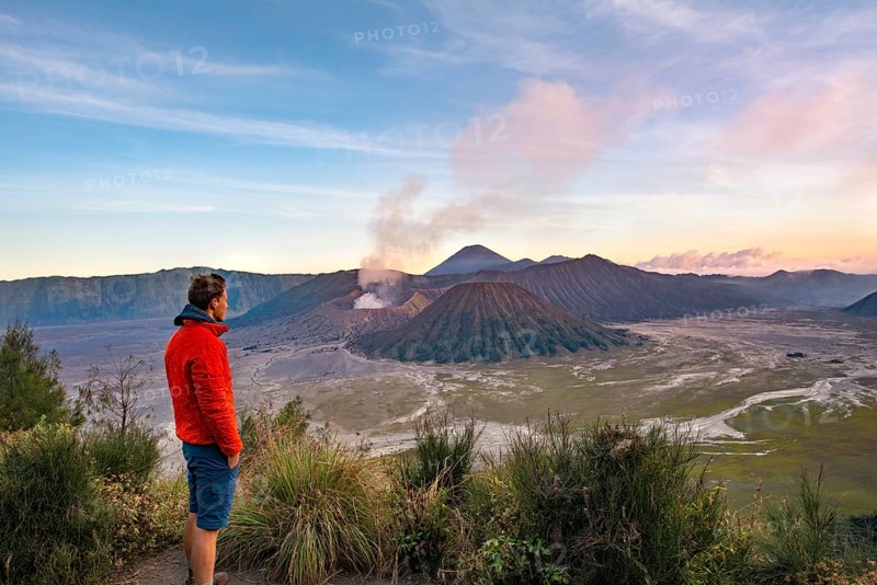 Young man in front of volcanic landscape at sunset