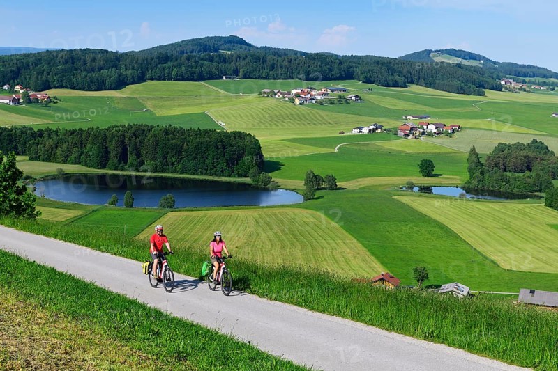 Couple with electric bikes at Buchberg with view of Lake Grossegelsee