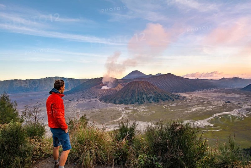 Young man in front of volcanic landscape at sunset