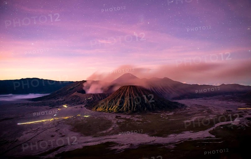 Volcanic landscape at sunrise with starry sky