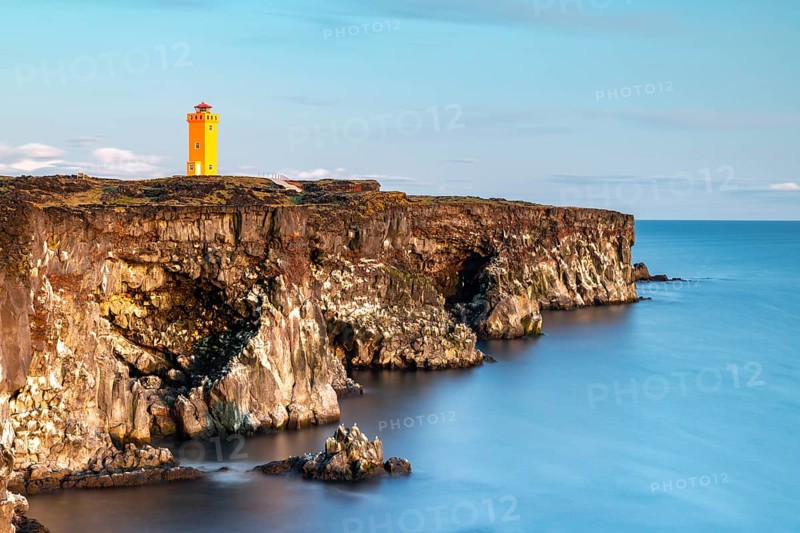 Orange lighthouse of Oendverdarnes stands at cliff coast