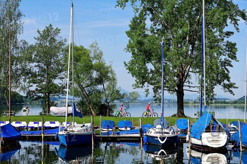 Couple with electric bikes in the port of Matzing on Lake Wallersee