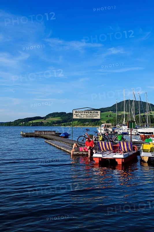 Couple with electric bikes pauses on a landing stage at Lake Obertrumer See
