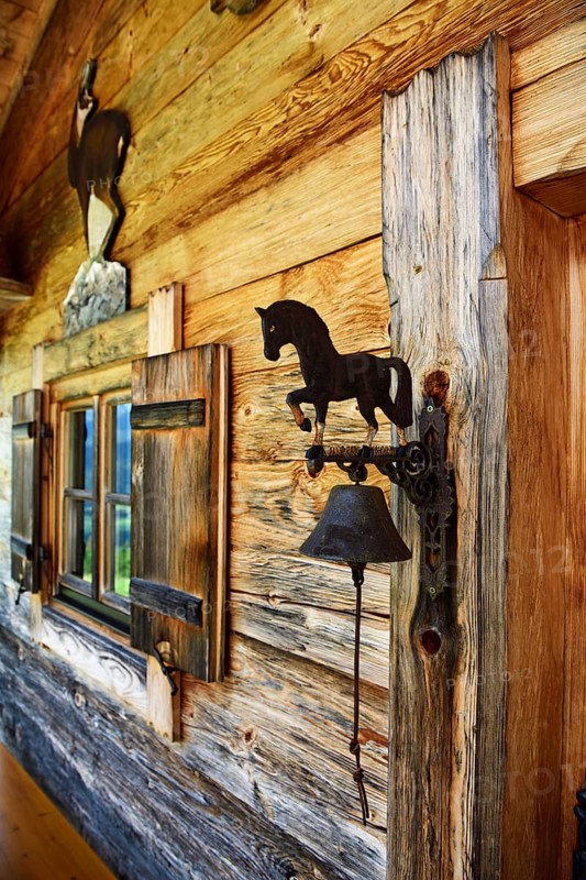 Small Swiss stone pine hut next to the mountain inn Streichen with bell made of wrought iron