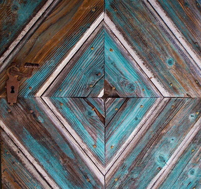 Old wooden house door with diamond-shaped pattern on a historical farmhouse