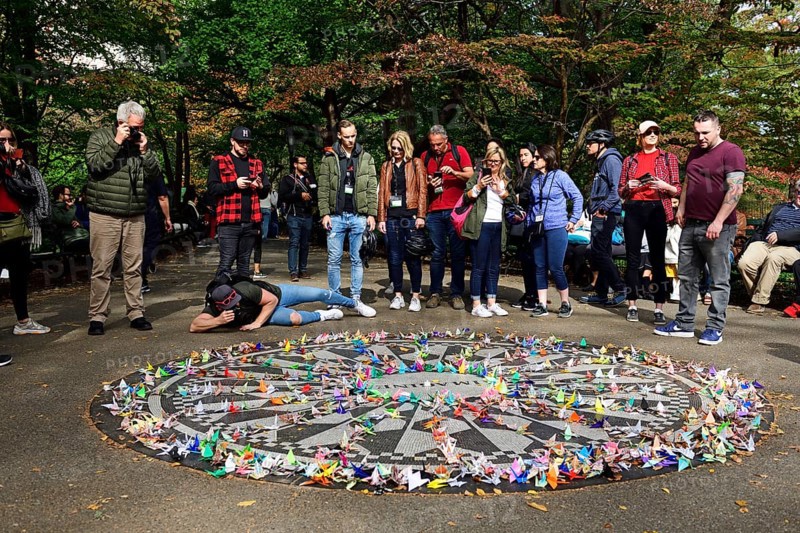 Tourists photograph the John Lennon Memorial