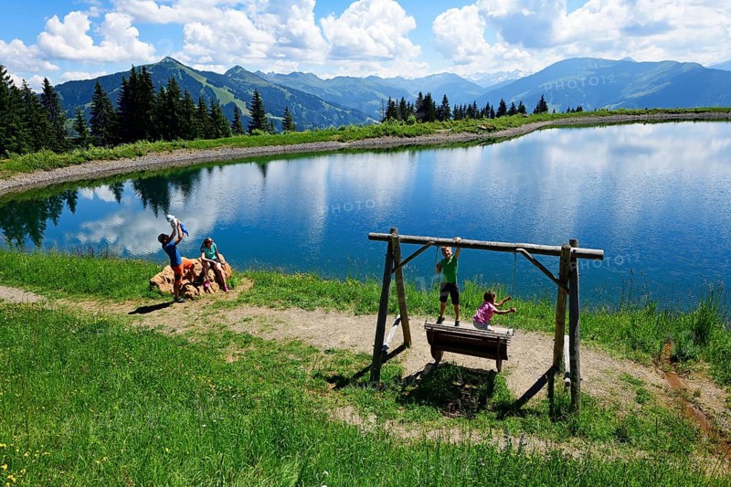 Family playing during a hike at the storage lake at the middle station