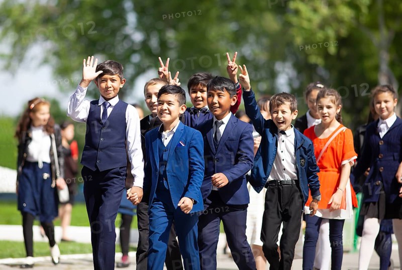 Happy students in evening dress on the university boulevard