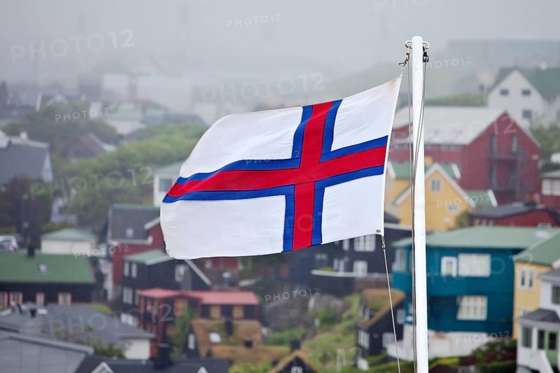 Faroese flag in front of houses in the fog