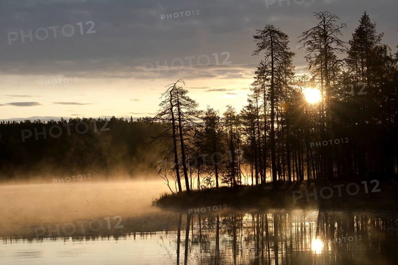 Sunrise with fog at a lake in the Finnish Taiga