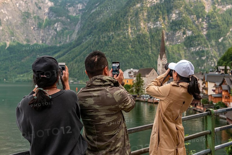 Asian tourists photograph the old town of Hallstatt