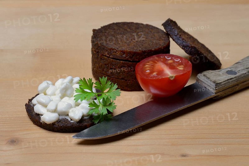 Pumpernickel disc covered with cream cheese