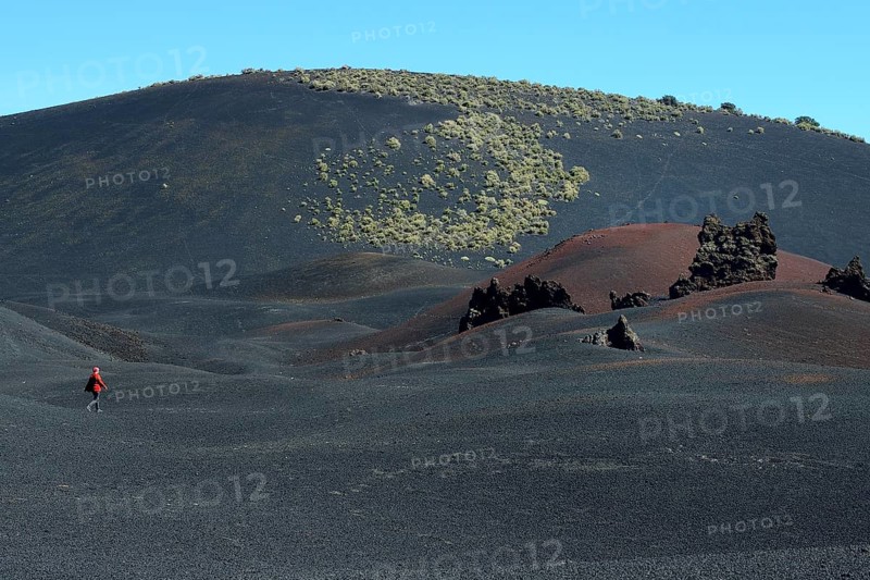 Wandering woman in volcanic lunar landscape