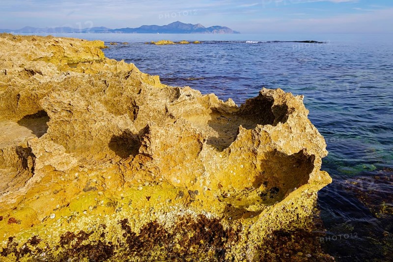 Sharp-edged eroded limestone cliffs on the coast near Can Picafort