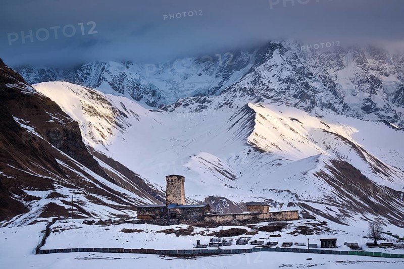 Watchtower in front of a mountain scenery at sunrise