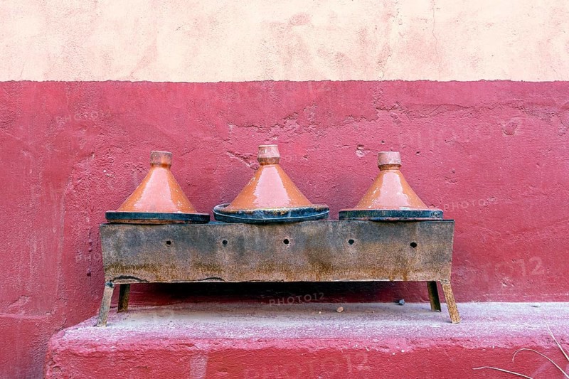 Three clay tagine pots on portable barbeque