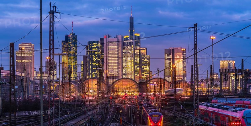 Train and tracks in front of main station and skyline Frankfurt Main in the evening
