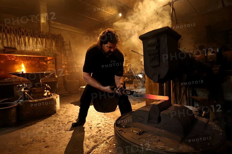 Blacksmith at the forge hammer
