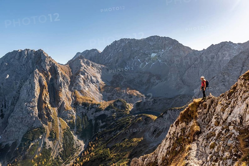 Mountaineer with climbing helmet stands on a rocky outcrop