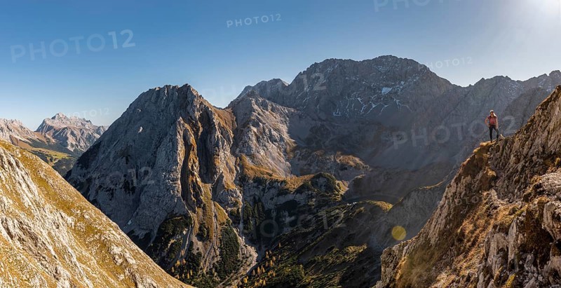 Mountaineer with climbing helmet stands on a rocky outcrop