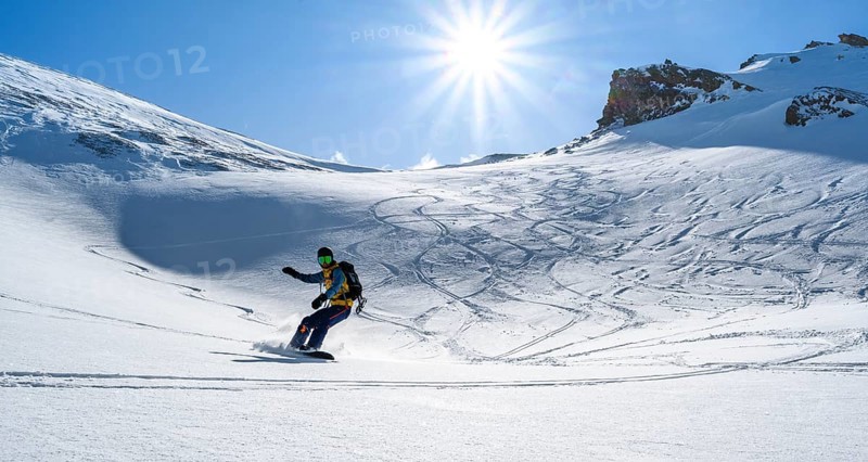 Snowboarder with splitboard rides in the snow