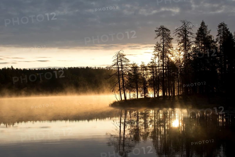 Sunrise with fog at a lake in the Finnish Taiga