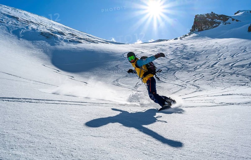 Snowboarder with splitboard rides in the snow