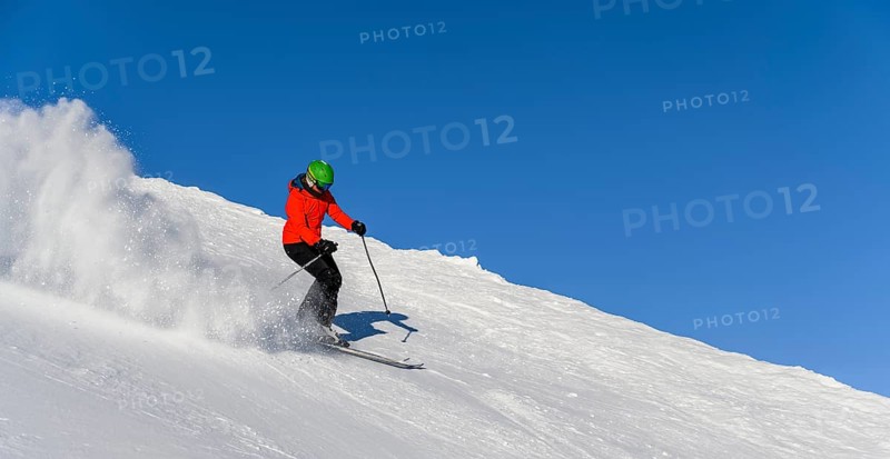 Skier descending steep slope