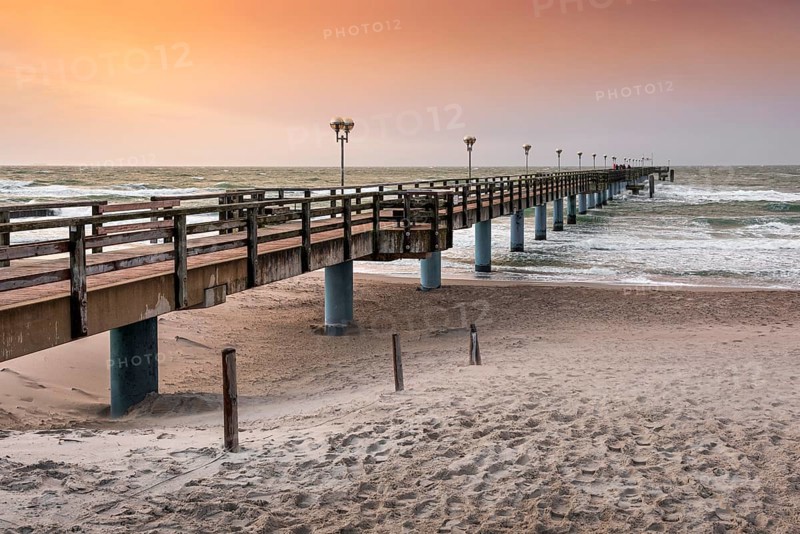 Pier on the beach of the Baltic Sea at sunset