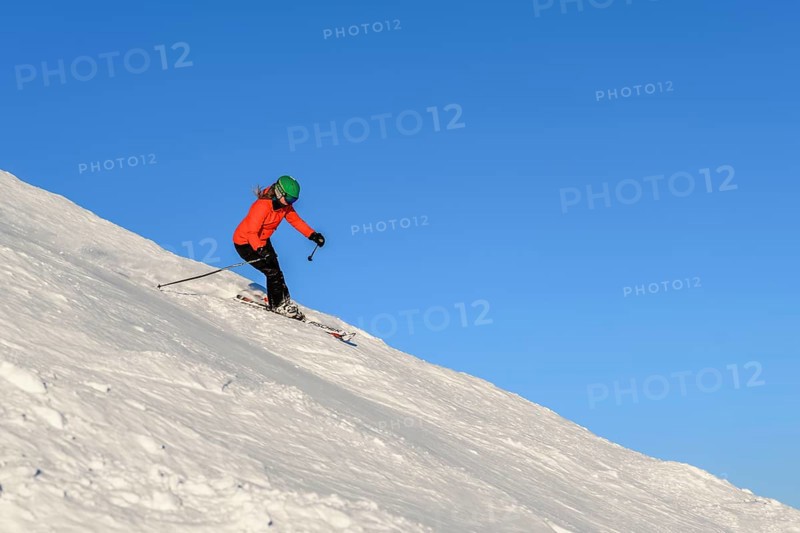 Female skier descending steep slope