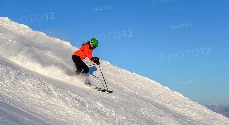 Female skier descending steep slope