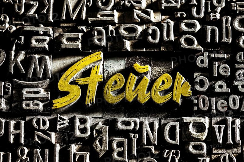 Old lead letters with golden writing show the word tax