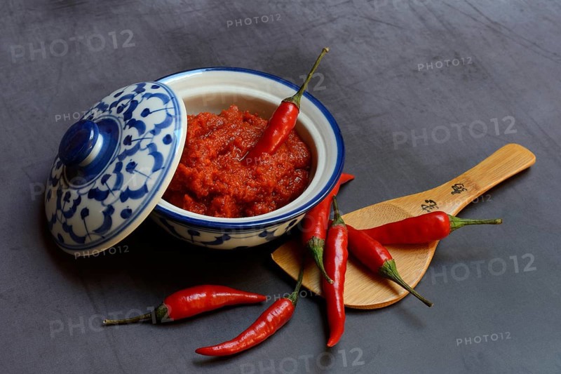 Red Thai curry paste in a bowl and red chilli peppers