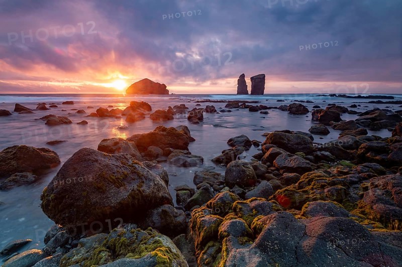 Sunset on a stony coast with huge rocks in the Atlantic Ocean