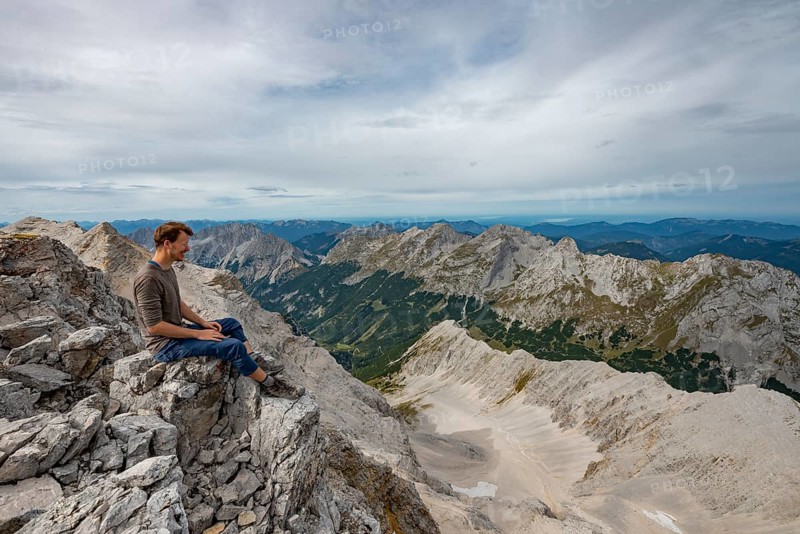Hiker sitting at the summit of the Birkkarspitze
