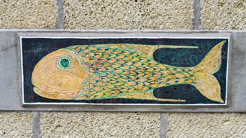 Pottery with fish motif on a house wall