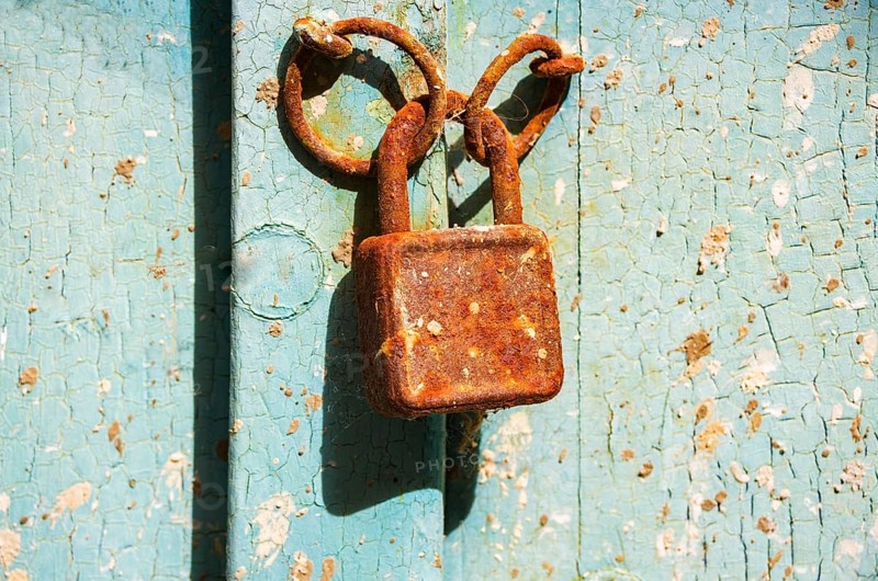 Old rusty door lock on weathered wooden door