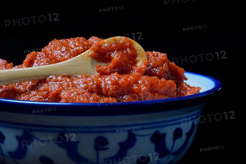Red Thai curry paste with spoon in bowl