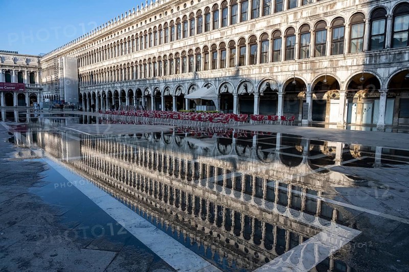 Reflection of the procurations at Acqua alta on St. Mark's Square
