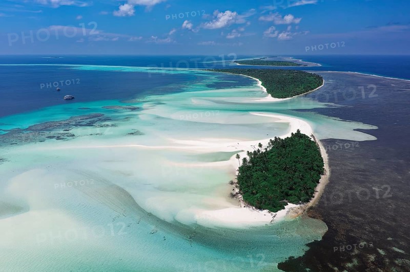 Uninhabited chain of islands with a wide sandbank on the eastern outer reef