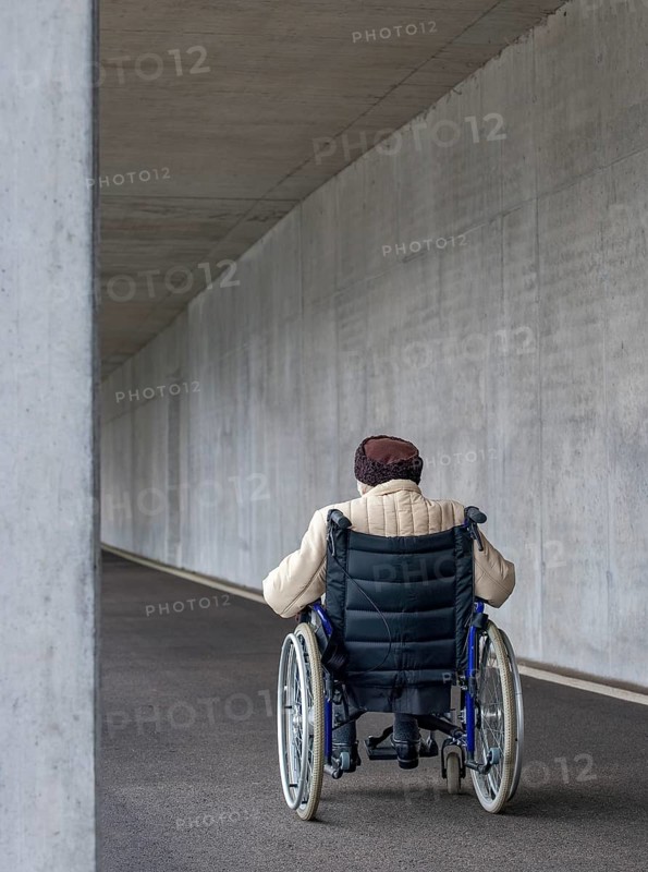 Senior citizen in a wheelchair in an underpass