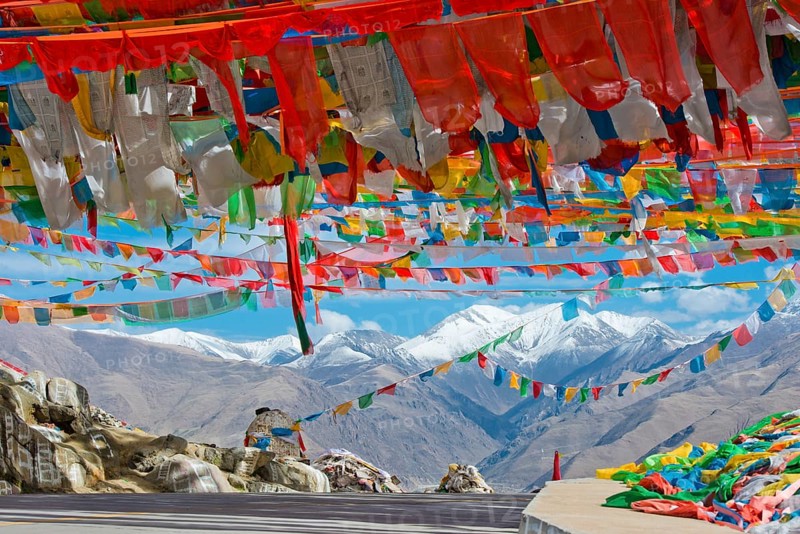 Pass road with Buddhist prayer flags at the Nachan La Pass (4500 m) above the Kyichu Valley