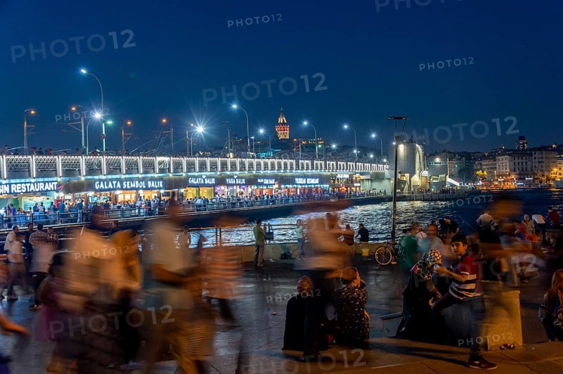 People in front of the Galata Bridge at night