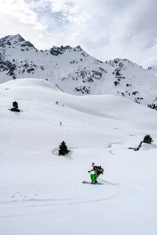 Ski tourers on the descent in deep snow